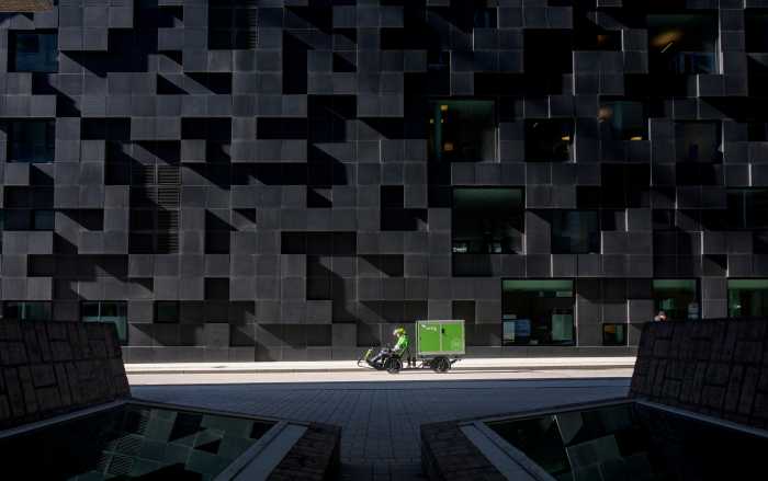 Grön elcykel framför svart vägg