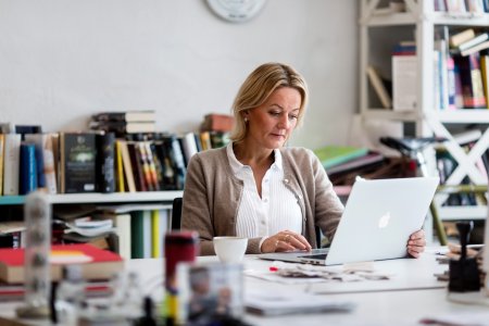 Kvinna sitter framför laptop