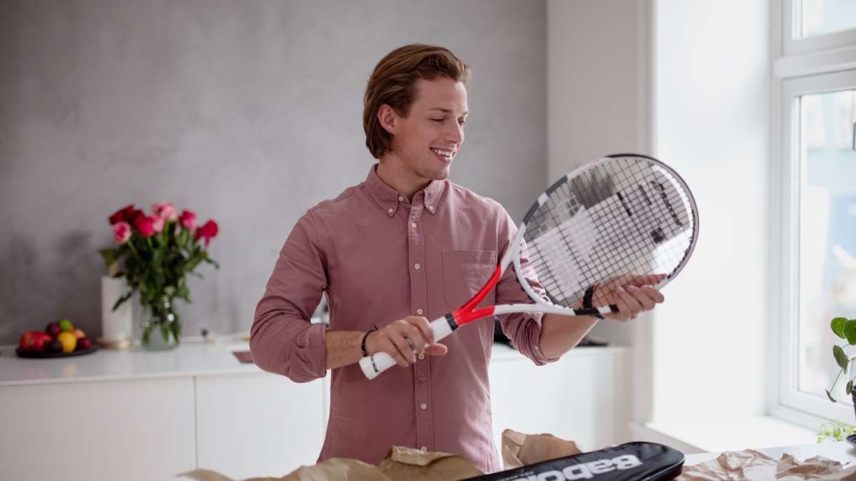 En glad kille med ett tennisracket