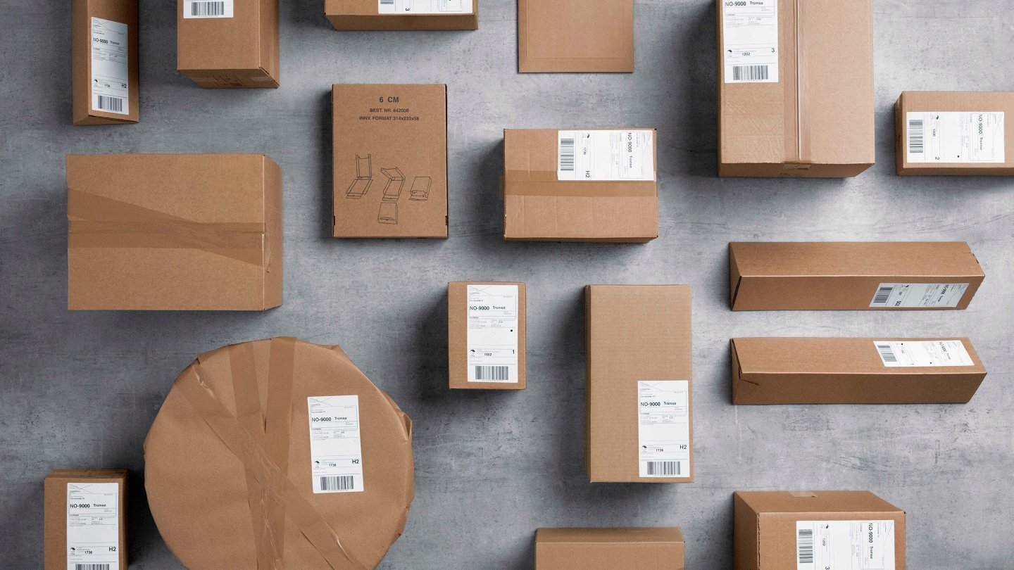 Packages in gray paper in various formats are spread over a gray floor.