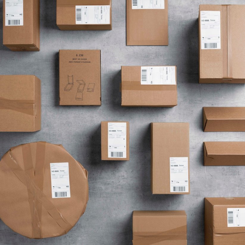 Packages in gray paper in various formats are spread over a gray floor.