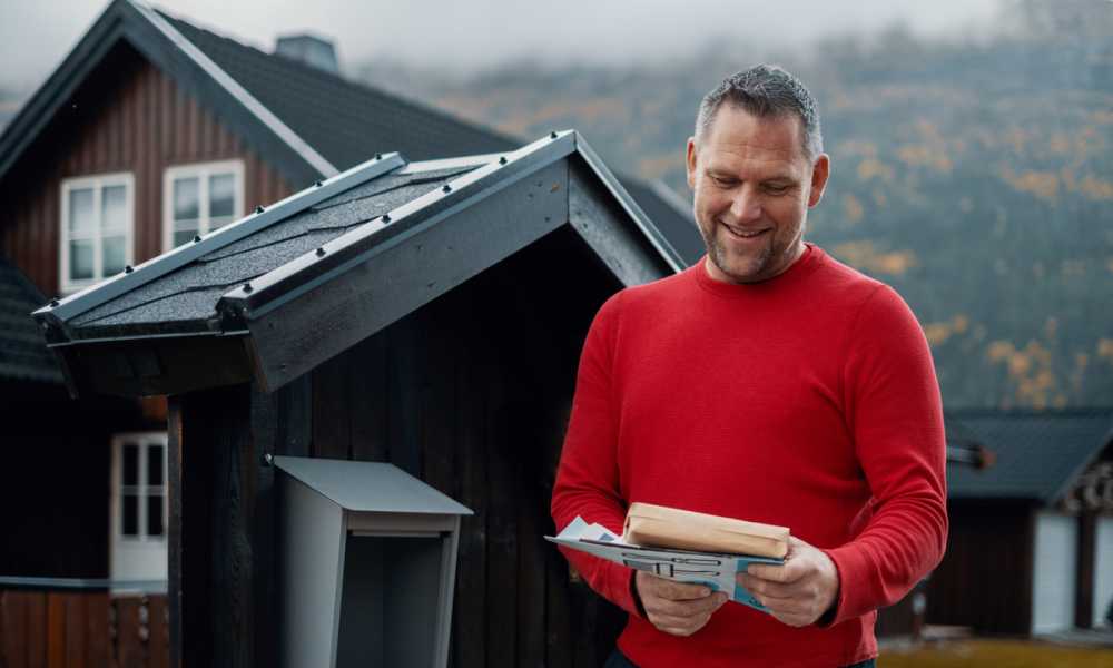 Man standing in front of mailbox with parcel