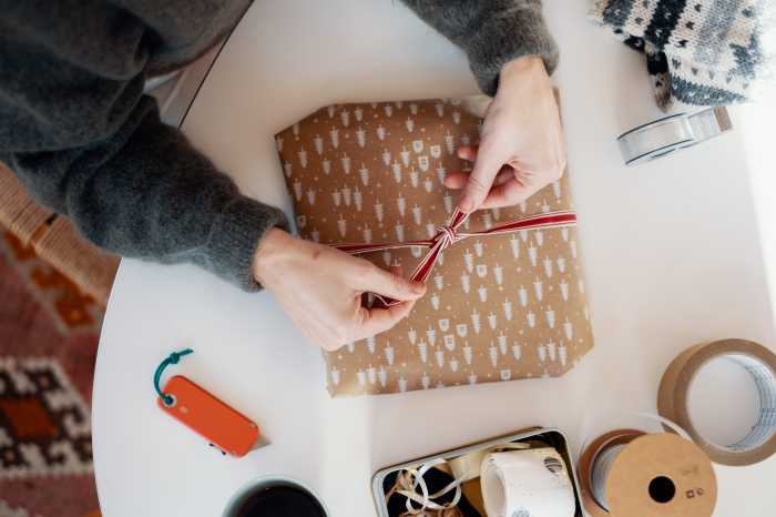 Plånbok med kreditkort, grankvist, smartphone som visar en produktbild i en webbutik.