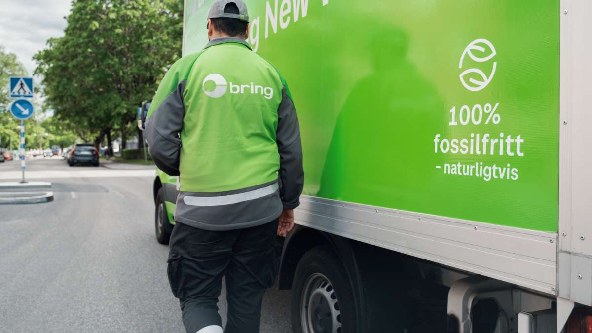 En Bring chaufför går bredvid budbil som det står 100% fossilfritt - naturligtvis på