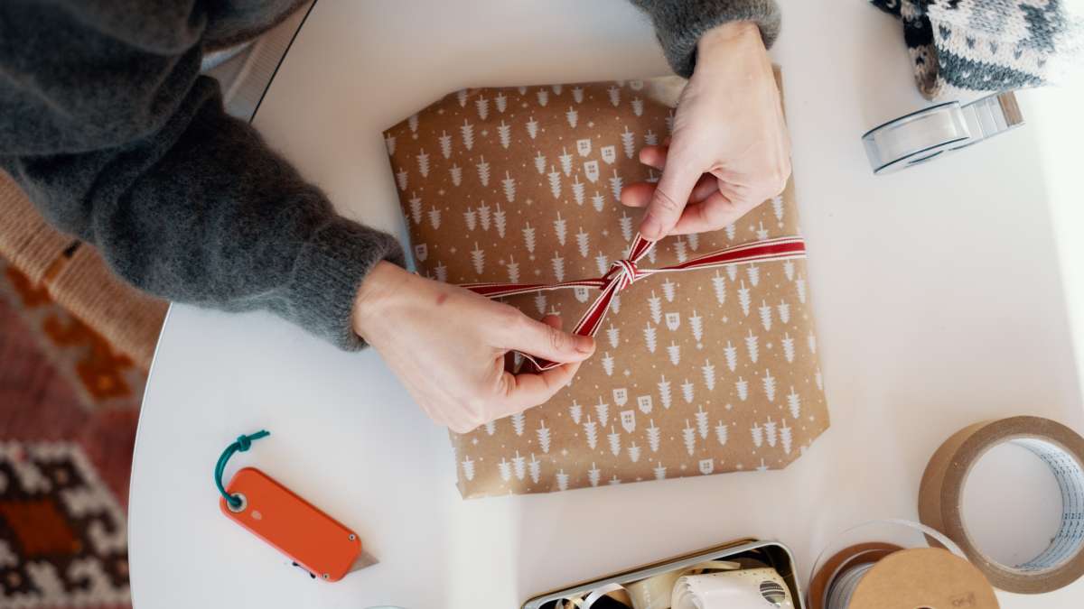 Plånbok med kreditkort, grankvist, smartphone som visar en produktbild i en webbutik.