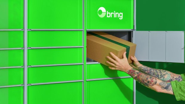 Person tar ut ett paket ur en Bring paketbox