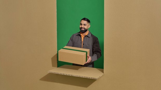 En man tar emot i ett paket på ett ombud