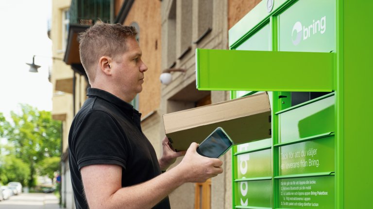 Man tar ut ett paket ur en Bring paketbox