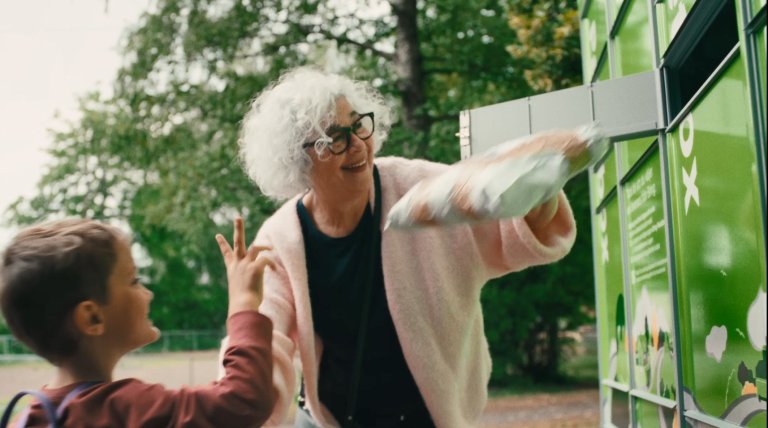 Äldre dam och barn returnerar ett paket i en Bring paketbox