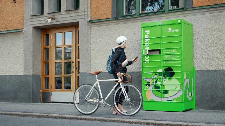 Tjej med cykel härmtar ett paket ur en paketbox