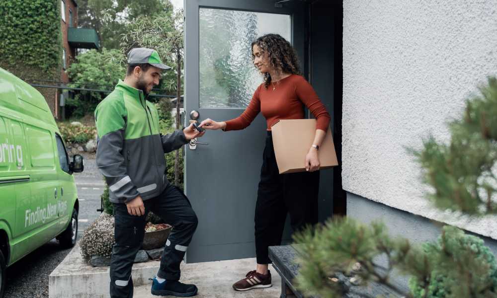 Ett bud levererar ett paket hemma hos en kvinna