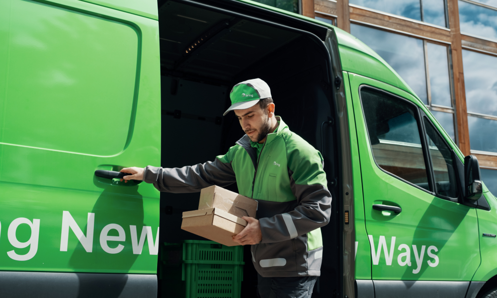 Ett paketbud bär ut paket ur sin budbil